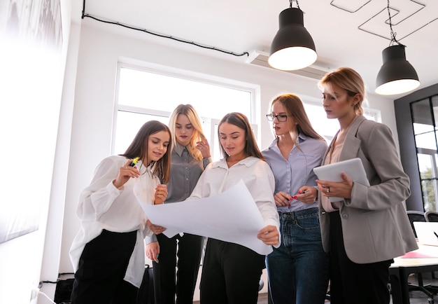 Free photo low angle corporate women checking plans